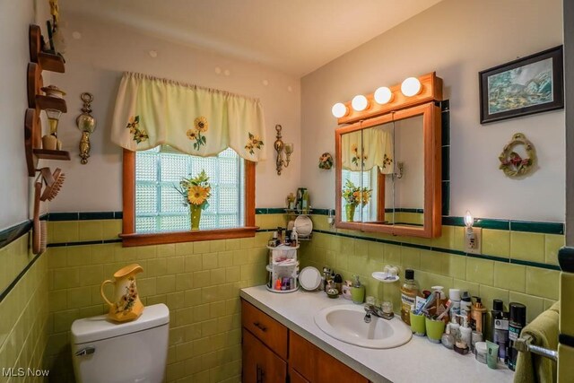 5920 Renninger Rd, New Franklin, OH 44319 - bathroom featuring vanity, toilet, tile walls, and a wainscoted wall