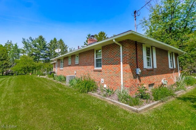5920 Renninger Rd, New Franklin, OH 44319 - view of side of home with brick siding, a chimney, a yard, and central air condition unit