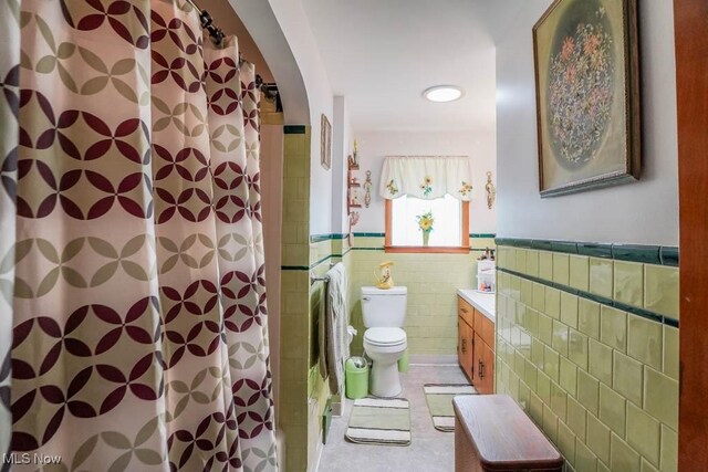 5920 Renninger Rd, New Franklin, OH 44319 - full bathroom featuring toilet, tile walls, a wainscoted wall, and vanity