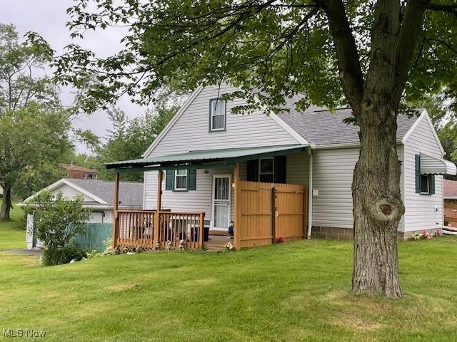 2410 Perry Dr SW, Canton, OH 44706 - rear view of house featuring a lawn, roof with shingles, and a deck