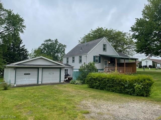 2410 Perry Dr SW, Canton, OH 44706 - rear view of property featuring a detached garage, a lawn, an outbuilding, and a porch