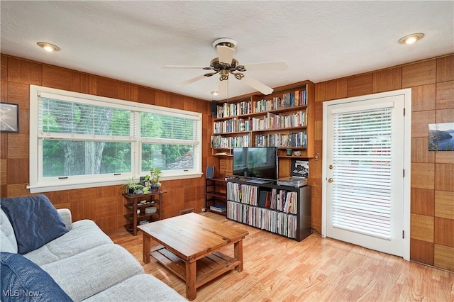 4418 Temblett Ter, South Euclid, OH 44121 - living area with wooden walls, a ceiling fan, and light wood finished floors