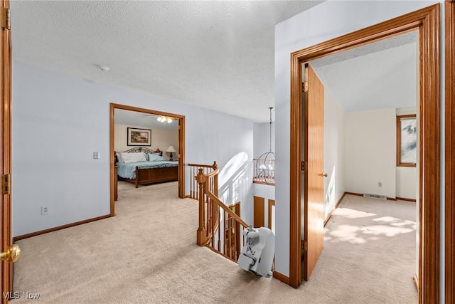 5011 Buttonbush Ln, North Royalton, OH 44133 - corridor with an upstairs landing, light colored carpet, baseboards, and a textured ceiling