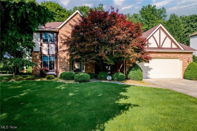 5011 Buttonbush Ln, North Royalton, OH 44133 - tudor house featuring brick siding, a front yard, and concrete driveway