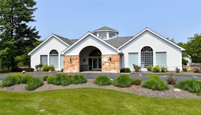 335 Devon Pond, Aurora, OH 44202 - view of front of house with french doors, stone siding, a front yard, and a shingled roof