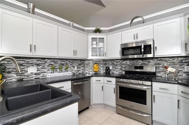 335 Devon Pond, Aurora, OH 44202 - kitchen with appliances with stainless steel finishes, a sink, light tile patterned floors, backsplash, and dark countertops
