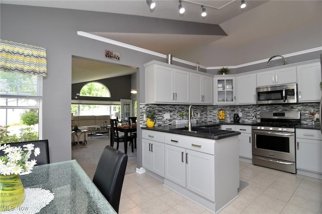 335 Devon Pond, Aurora, OH 44202 - kitchen with stainless steel appliances, a sink, decorative backsplash, dark countertops, and crown molding