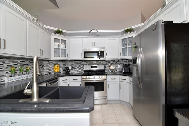 335 Devon Pond, Aurora, OH 44202 - kitchen featuring stainless steel appliances, dark countertops, tasteful backsplash, white cabinets, and light tile patterned flooring