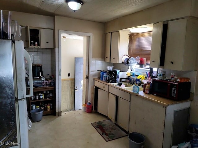 4549 Lee Rd, Cleveland, OH 44128 - kitchen with black microwave, freestanding refrigerator, white cabinetry, and light countertops