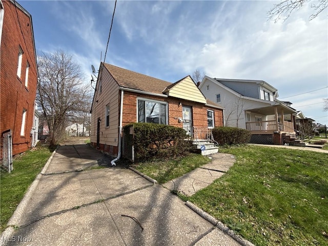 3877 E 153rd St, Cleveland, OH 44128 - bungalow with a front yard, concrete driveway, a shingled roof, and a porch