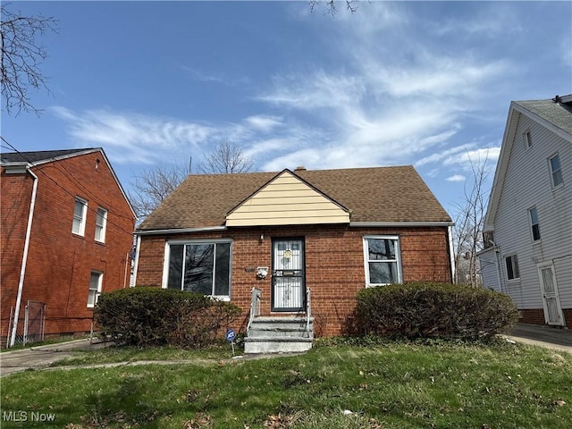 3877 E 153rd St, Cleveland, OH 44128 - bungalow-style home with a shingled roof, a front lawn, and brick siding