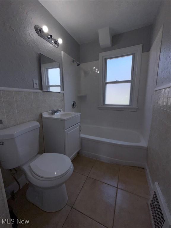 3877 E 153rd St, Cleveland, OH 44128 - full bath featuring tile walls, toilet, vanity, bathing tub / shower combination, and tile patterned floors