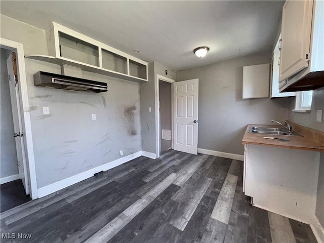 3877 E 153rd St, Cleveland, OH 44128 - kitchen featuring dark wood-style floors, baseboards, a sink, and white cabinets