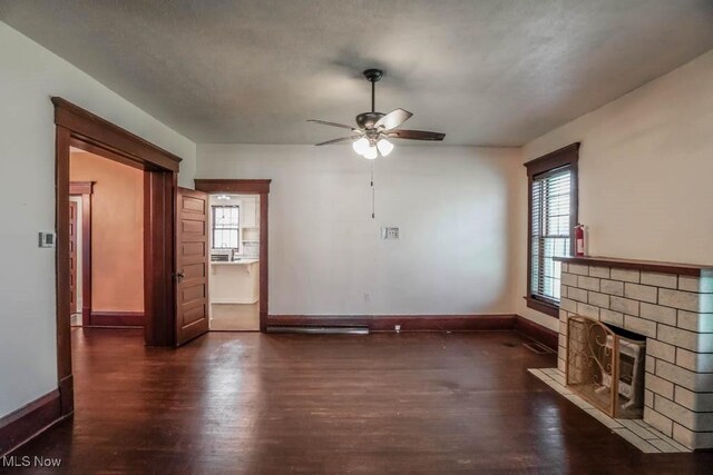 490 N Main St, Magnolia, OH 44643 - unfurnished living room featuring dark wood-type flooring, a fireplace with flush hearth, ceiling fan, and plenty of natural light