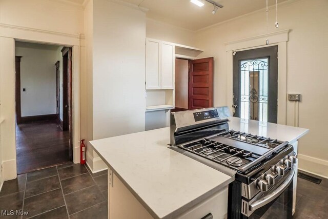 490 N Main St, Magnolia, OH 44643 - kitchen featuring stainless steel gas range, a kitchen island, white cabinets, and light countertops