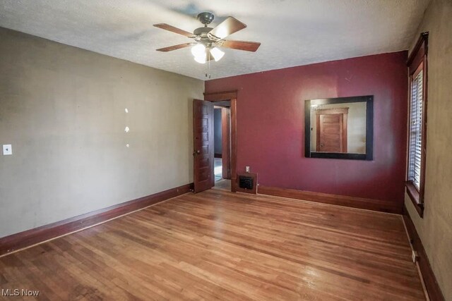 490 N Main St, Magnolia, OH 44643 - unfurnished room with light wood finished floors, baseboards, ceiling fan, and a textured ceiling