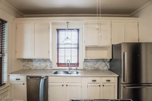 490 N Main St, Magnolia, OH 44643 - kitchen with stainless steel appliances, a sink, light countertops, white cabinetry, and ornamental molding