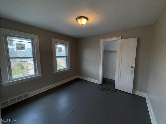 15002 Kingsford Ave, Cleveland, OH 44128 - unfurnished bedroom featuring baseboards, a closet, and concrete flooring