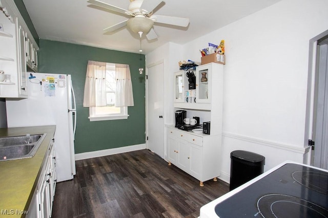 208 Como St, Struthers, OH 44471 - kitchen featuring dark wood-style flooring, a ceiling fan, white cabinets, a sink, and baseboards