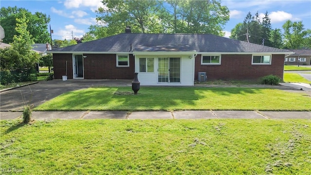 525 Cynthia Dr, Campbell, OH 44405 - view of front facade featuring brick siding, a front yard, and a chimney