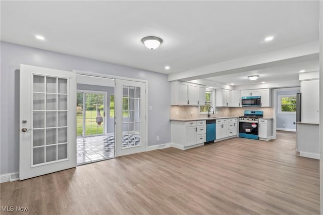 525 Cynthia Dr, Campbell, OH 44405 - kitchen with black microwave, stainless steel range oven, dishwasher, light wood-type flooring, and white cabinetry