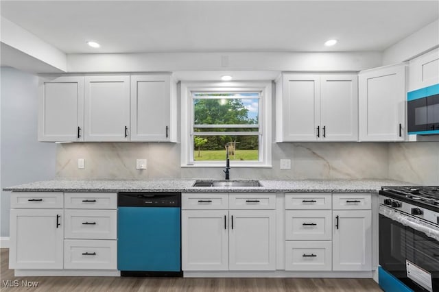 525 Cynthia Dr, Campbell, OH 44405 - kitchen with dishwashing machine, stainless steel range with gas stovetop, light wood-style floors, white cabinets, and recessed lighting