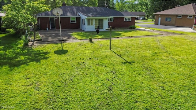 525 Cynthia Dr, Campbell, OH 44405 - back of property with a chimney, a lawn, and brick siding