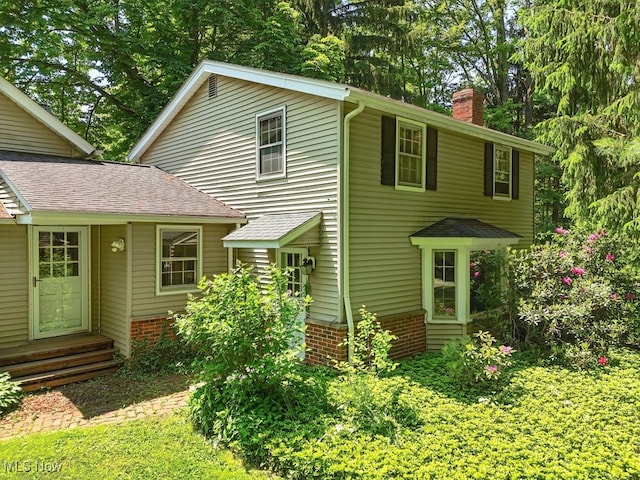 37845 Miles Rd, Moreland Hills, OH 44022 - view of front facade featuring a chimney, brick siding, entry steps, and a shingled roof