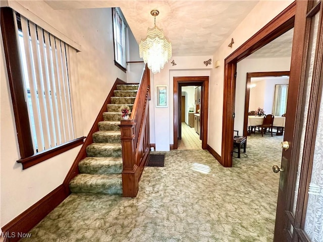 808 Gilbert Ave, Follansbee, WV 26037 - entryway featuring carpet, a chandelier, stairs, and baseboards