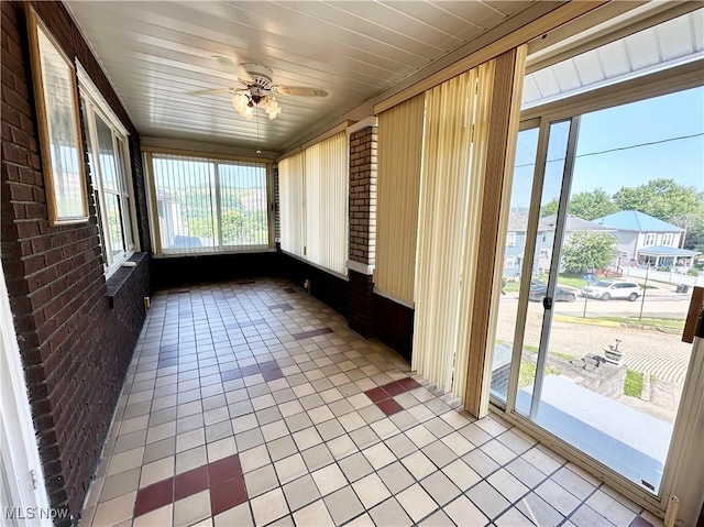 808 Gilbert Ave, Follansbee, WV 26037 - unfurnished sunroom featuring brick wall, a ceiling fan, and tile patterned flooring
