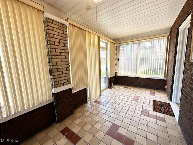 808 Gilbert Ave, Follansbee, WV 26037 - unfurnished sunroom featuring brick wall and tile patterned floors