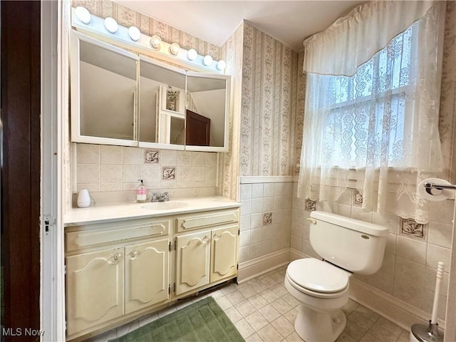 808 Gilbert Ave, Follansbee, WV 26037 - bathroom with wallpapered walls, vanity, toilet, tile patterned flooring, and tile walls