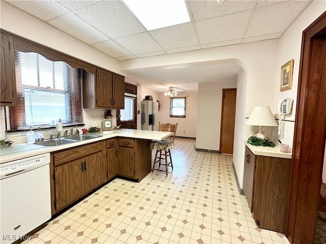 808 Gilbert Ave, Follansbee, WV 26037 - kitchen featuring white dishwasher, a drop ceiling, light floors, a sink, and a peninsula