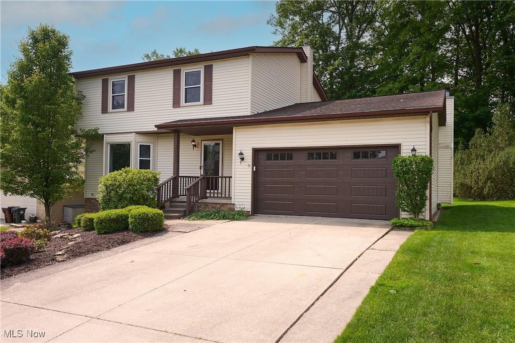 9201 Pleasant Lake Blvd, Parma, OH 44130 - traditional-style home featuring concrete driveway, a garage, and a front yard