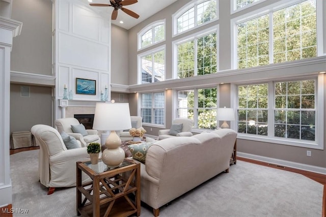 4679 Paxton Rd, Copley, OH 44321 - living room featuring a high ceiling, a large fireplace, ceiling fan, wood finished floors, and recessed lighting