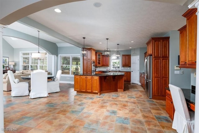 4679 Paxton Rd, Copley, OH 44321 - kitchen with stainless steel appliances, open floor plan, brown cabinets, arched walkways, and dark countertops