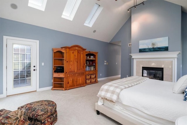 4679 Paxton Rd, Copley, OH 44321 - carpeted bedroom with a skylight, access to outside, high vaulted ceiling, and a tiled fireplace