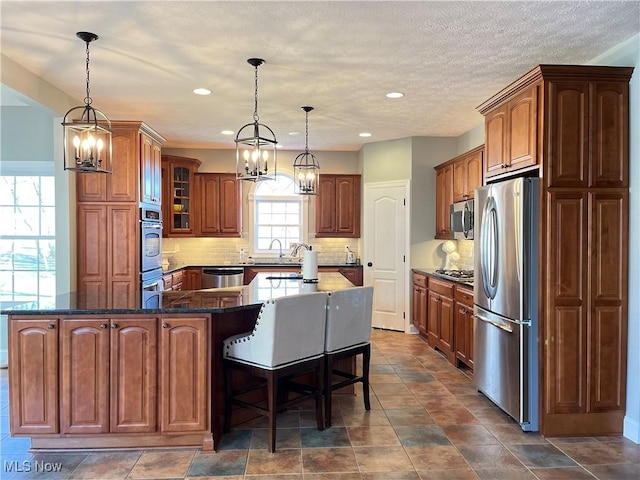 4679 Paxton Rd, Copley, OH 44321 - kitchen featuring appliances with stainless steel finishes, a chandelier, a spacious island, tasteful backsplash, and recessed lighting