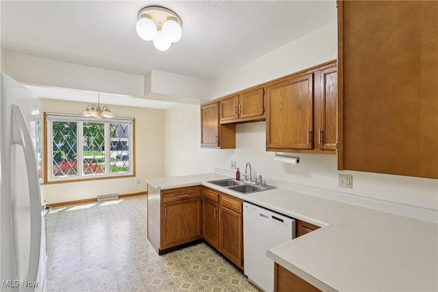 47 Tudor Ln Unit 6C, Kent, OH 44240 - kitchen featuring a sink, white appliances, a peninsula, light countertops, and a chandelier