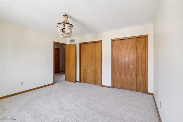 47 Tudor Ln Unit 6C, Kent, OH 44240 - unfurnished bedroom featuring two closets, carpet, a chandelier, and baseboards