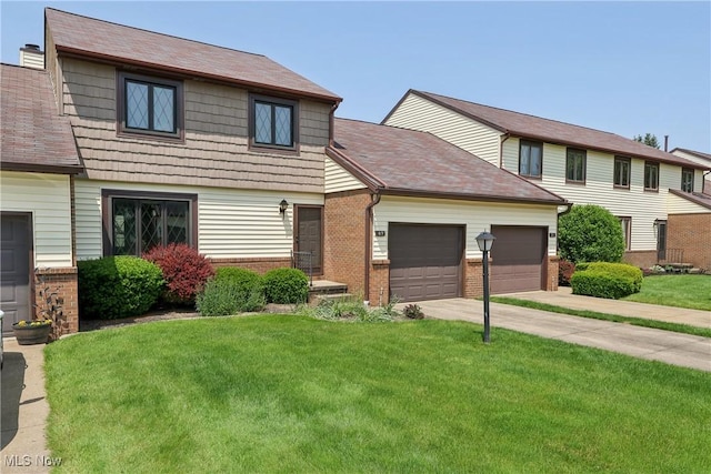 47 Tudor Ln Unit 6C, Kent, OH 44240 - view of front of house featuring brick siding, an attached garage, a front lawn, and driveway