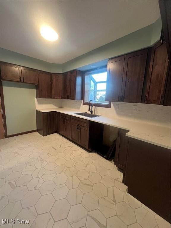 275 Cornell Ave, Amherst, OH 44001 - kitchen with a sink, light countertops, dark brown cabinetry, and light flooring