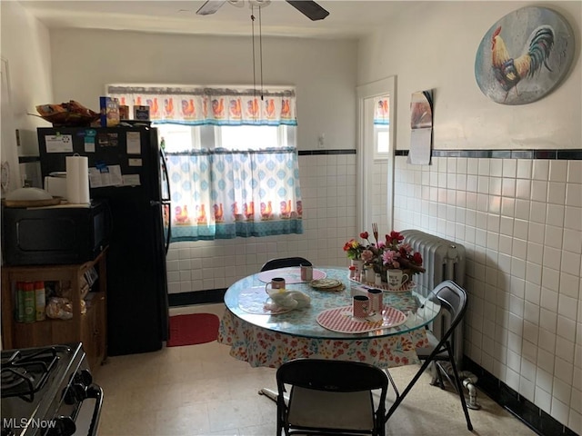 3526 E Blvd, Cleveland, OH 44105 - dining room with tile walls, a ceiling fan, and wainscoting