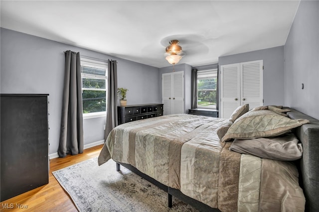 1167 Croyden Rd, Lyndhurst, OH 44124 - bedroom featuring two closets, light wood-style flooring, a ceiling fan, and baseboards