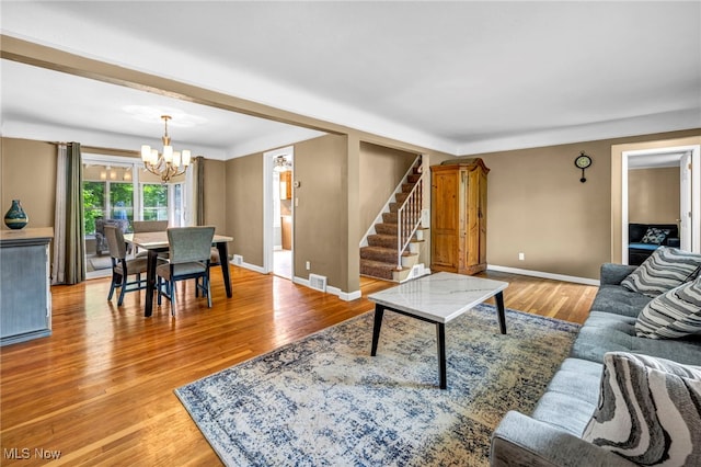 1167 Croyden Rd, Lyndhurst, OH 44124 - living area featuring stairway, a chandelier, light wood-style floors, and baseboards
