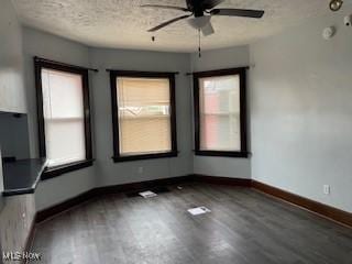 200 Stewart Ave NW, Massillon, OH 44646 - unfurnished dining area featuring wood finished floors, healthy amount of natural light, ceiling fan, baseboards, and a textured ceiling