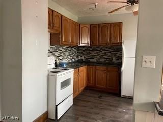 200 Stewart Ave NW, Massillon, OH 44646 - kitchen featuring white appliances, ceiling fan, decorative backsplash, brown cabinetry, and dark countertops