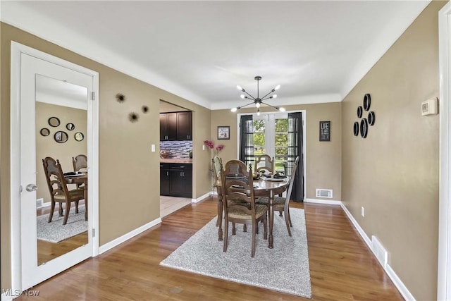 321 Justo Ln, Seven Hills, OH 44131 - dining room with a chandelier, wood finished floors, and baseboards