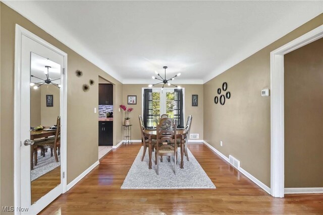 321 Justo Ln, Seven Hills, OH 44131 - dining area with a chandelier, light wood finished floors, and baseboards