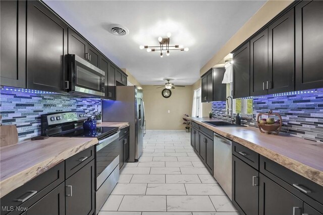 321 Justo Ln, Seven Hills, OH 44131 - kitchen featuring stainless steel appliances, a sink, dark cabinetry, and ceiling fan